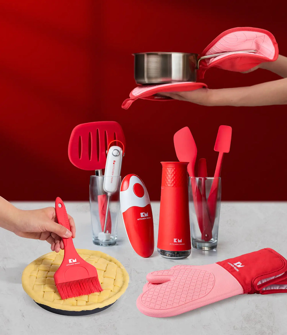 Kitchen Mama red kitchen tools and gadgets, including can opener, spatulas, grinder, brush, and oven mitt on a countertop.
