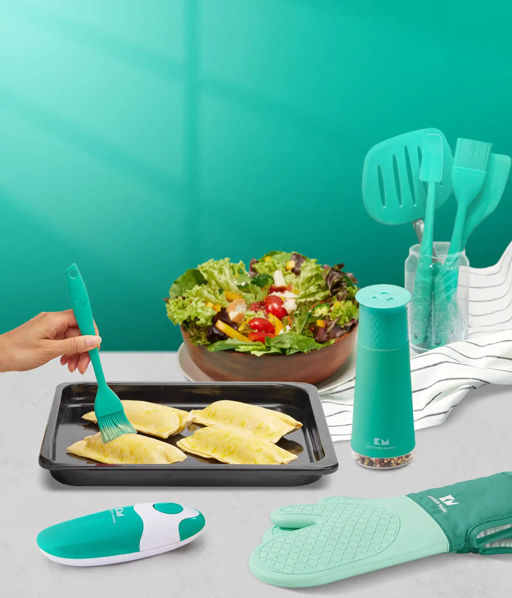 Kitchen Mama teal kitchen tools, including can opener, spatulas, brush, grinder, and oven mitt, used while preparing salad and pastries.